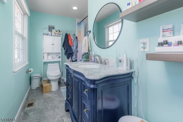 bathroom with plenty of natural light, toilet, curtained shower, and vanity