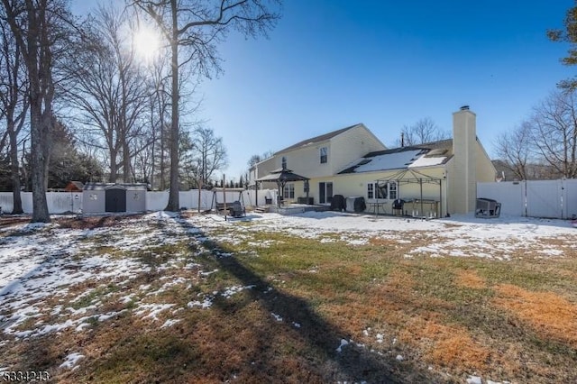 snow covered property with a gazebo and a shed