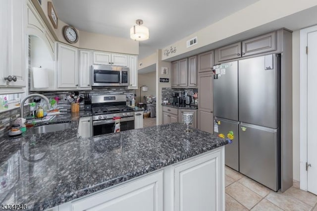 kitchen featuring white cabinetry, sink, dark stone countertops, decorative backsplash, and stainless steel appliances