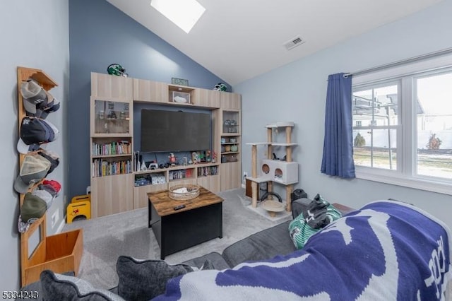 living room featuring vaulted ceiling with skylight