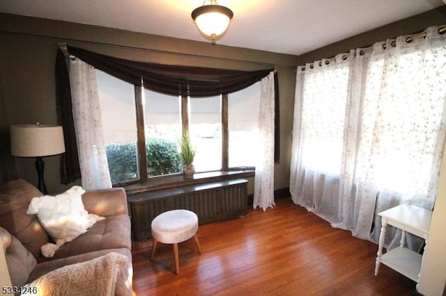 sitting room with radiator and wood-type flooring