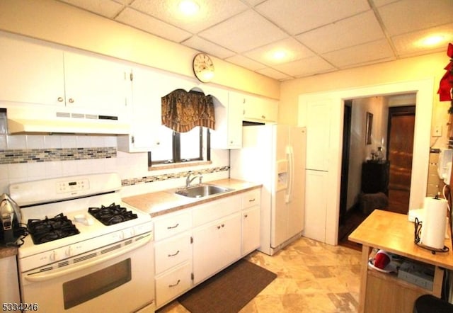 kitchen with sink, white appliances, a paneled ceiling, backsplash, and white cabinets