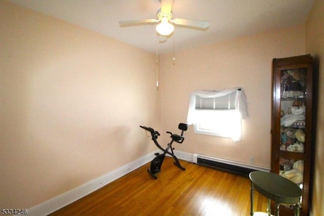 workout area with hardwood / wood-style flooring, ceiling fan, and baseboard heating