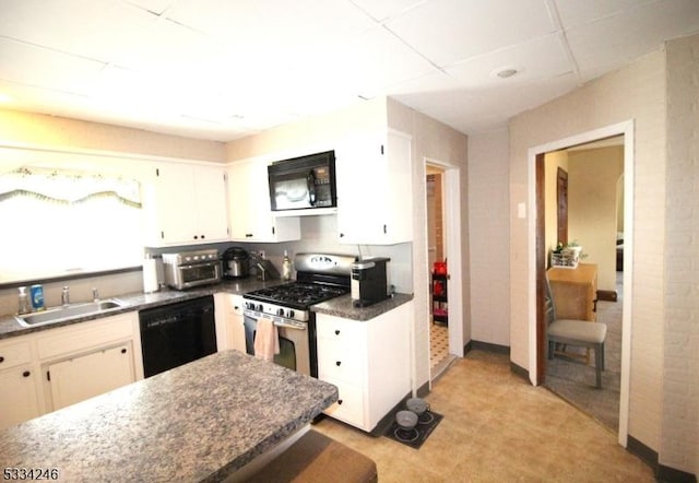 kitchen featuring white cabinetry, a paneled ceiling, sink, and black appliances