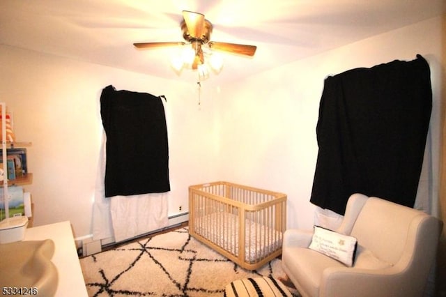 bedroom with a crib and ceiling fan