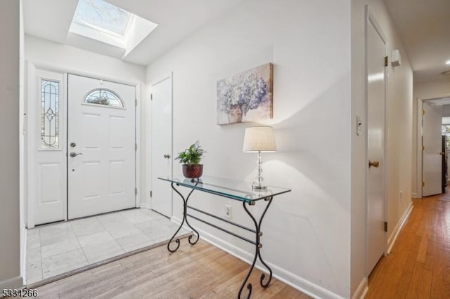 entryway with a skylight and light hardwood / wood-style flooring