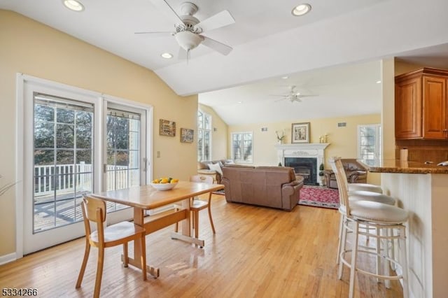 dining area featuring lofted ceiling, ceiling fan, and light hardwood / wood-style flooring