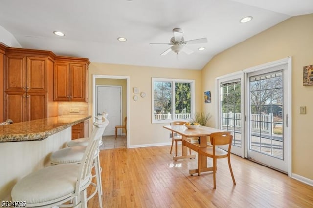 dining area with ceiling fan, lofted ceiling, and light hardwood / wood-style floors