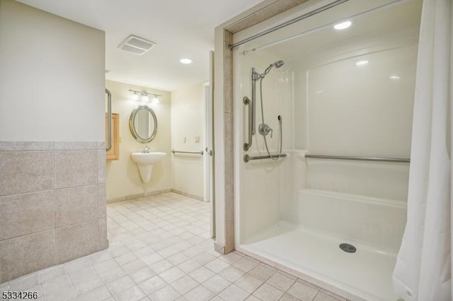 bathroom featuring tile walls and walk in shower