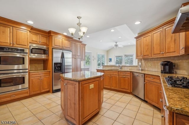 kitchen featuring lofted ceiling, tasteful backsplash, appliances with stainless steel finishes, a kitchen island, and pendant lighting