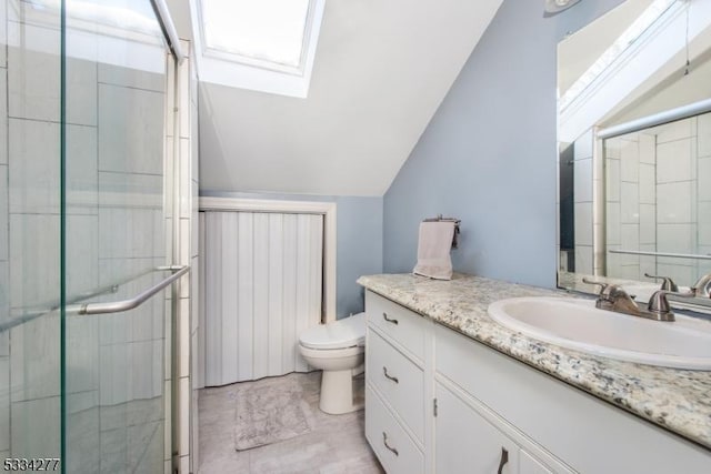 bathroom with toilet, vanity, lofted ceiling with skylight, and a shower with door