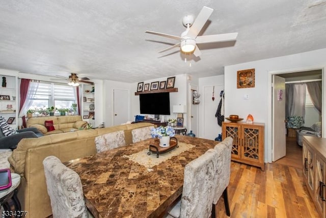 dining space featuring ceiling fan, a textured ceiling, and light wood-type flooring