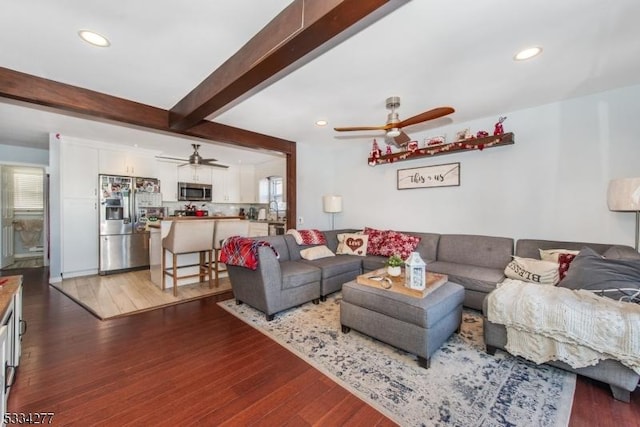 living room featuring dark hardwood / wood-style flooring, ceiling fan, and beam ceiling