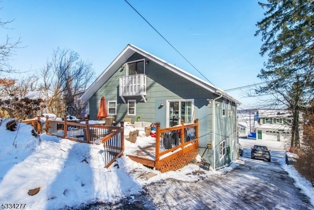 snow covered rear of property featuring a deck