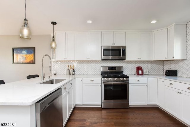 kitchen featuring decorative light fixtures, white cabinetry, sink, kitchen peninsula, and stainless steel appliances