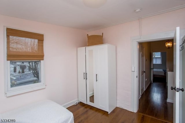 bedroom with dark wood-type flooring