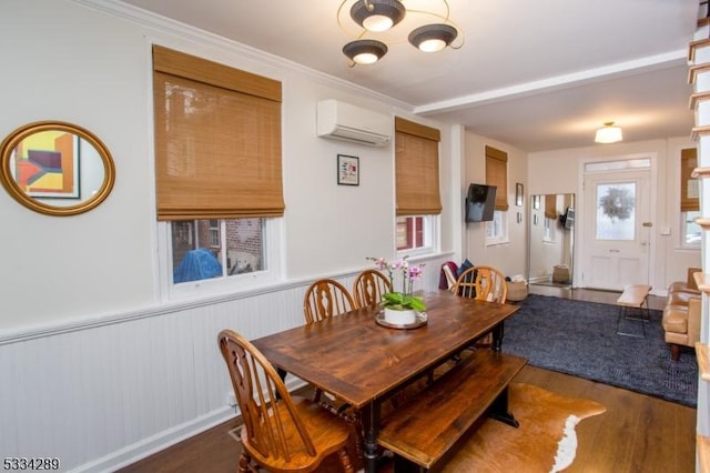 dining space with ornamental molding, dark hardwood / wood-style floors, and a wall mounted AC