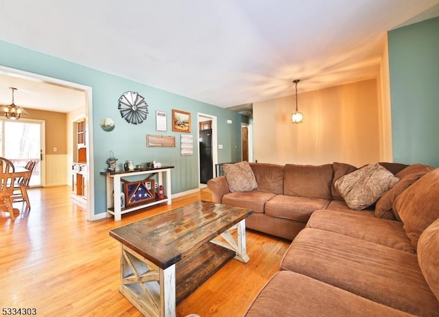 living room featuring an inviting chandelier and light hardwood / wood-style flooring