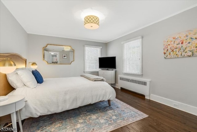 bedroom with radiator heating unit and dark hardwood / wood-style flooring