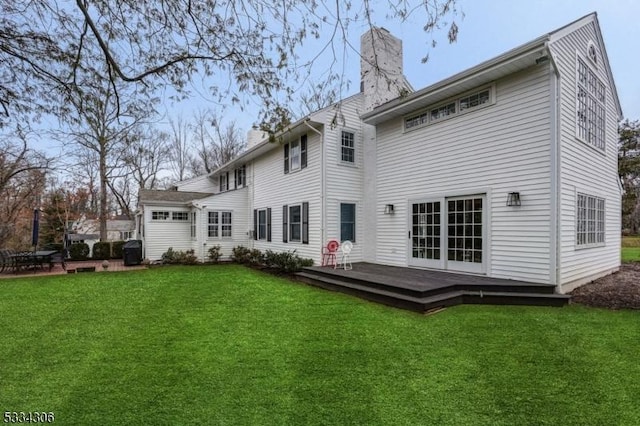 rear view of house with a wooden deck and a yard