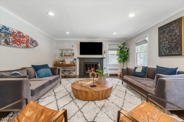 living room with ornamental molding, radiator, and a brick fireplace