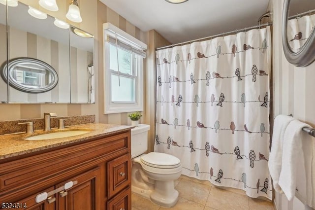 bathroom with tile patterned flooring, vanity, walk in shower, and toilet