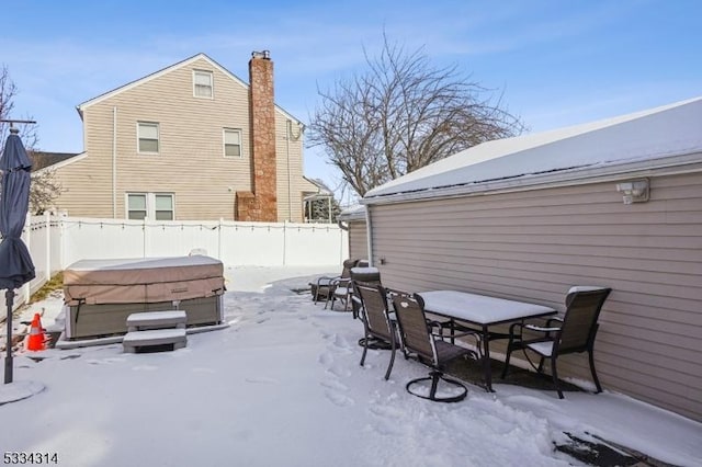 snow covered patio with a hot tub