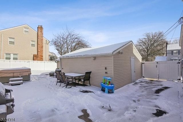 snow covered house featuring a hot tub