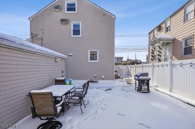 snow covered patio featuring a grill