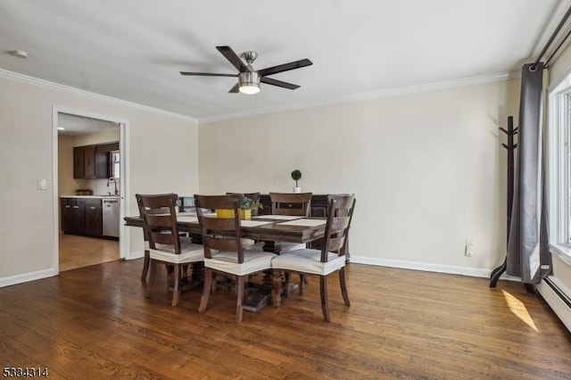 dining room featuring hardwood / wood-style flooring, crown molding, and sink