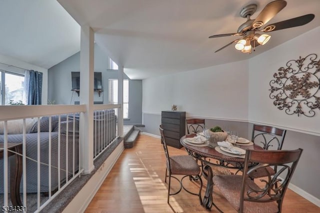 dining area featuring vaulted ceiling and light hardwood / wood-style floors