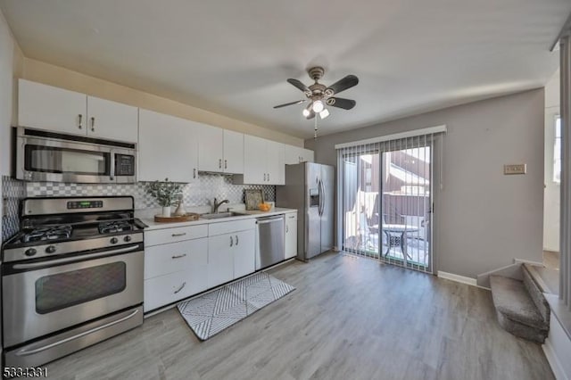 kitchen with white cabinetry, light wood-type flooring, tasteful backsplash, and appliances with stainless steel finishes