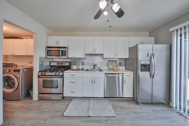 kitchen with white cabinetry, washer / clothes dryer, sink, and appliances with stainless steel finishes