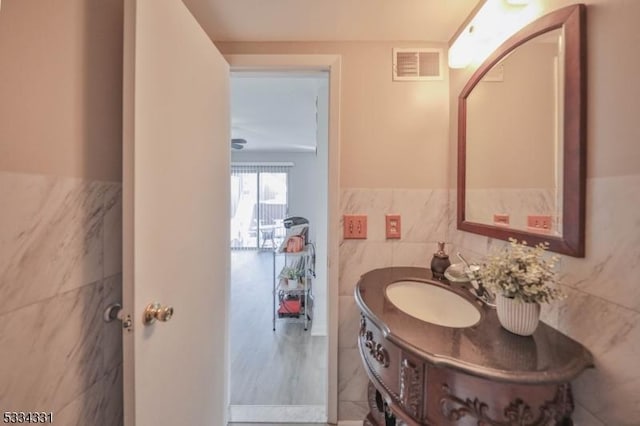 bathroom with tile walls and vanity