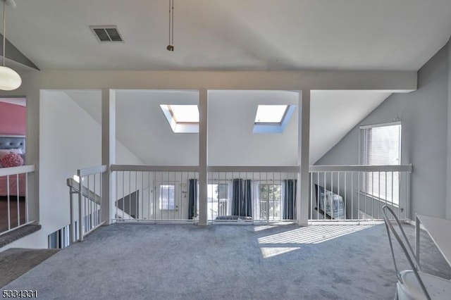 carpeted spare room with a healthy amount of sunlight and vaulted ceiling with beams