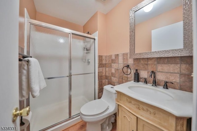 bathroom featuring vanity, tile walls, an enclosed shower, and toilet