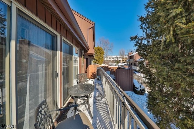 view of snow covered back of property