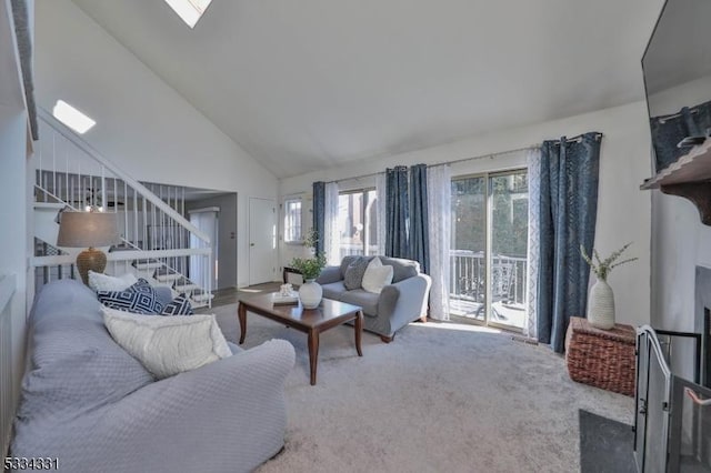 carpeted living room with high vaulted ceiling