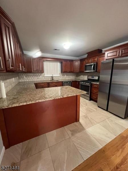 kitchen with sink, backsplash, stainless steel appliances, and kitchen peninsula