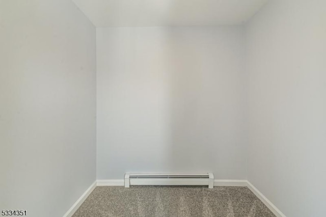 spare room featuring carpet floors and a baseboard heating unit