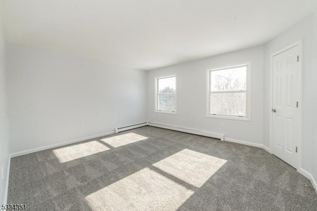 unfurnished room featuring baseboard heating and dark colored carpet