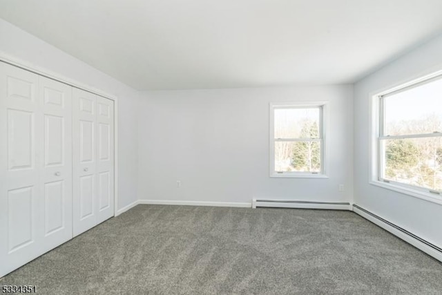 unfurnished bedroom featuring a baseboard radiator, light carpet, and a closet