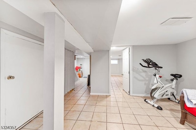 exercise room with light tile patterned flooring