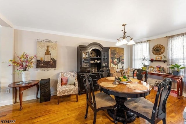 dining room with light hardwood / wood-style flooring and a chandelier