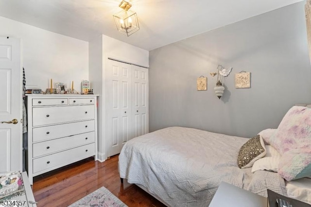 bedroom with dark hardwood / wood-style flooring and a closet