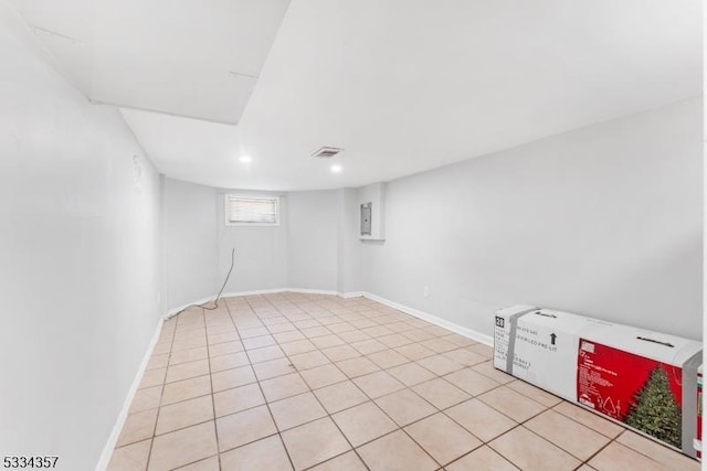 basement featuring light tile patterned floors and electric panel