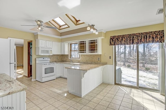 kitchen with a skylight, white cabinetry, sink, kitchen peninsula, and white appliances