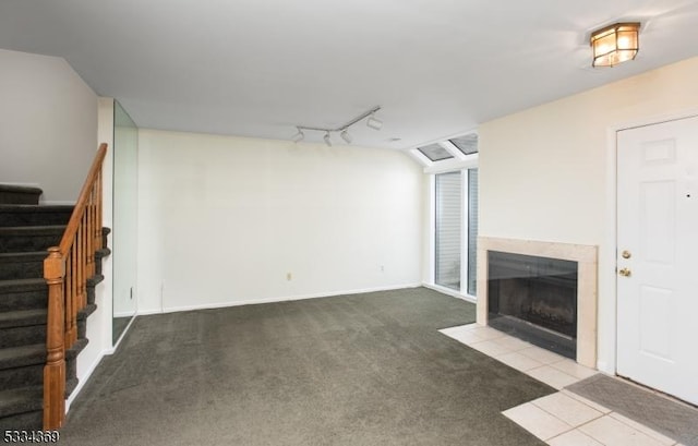 unfurnished living room featuring light carpet and track lighting