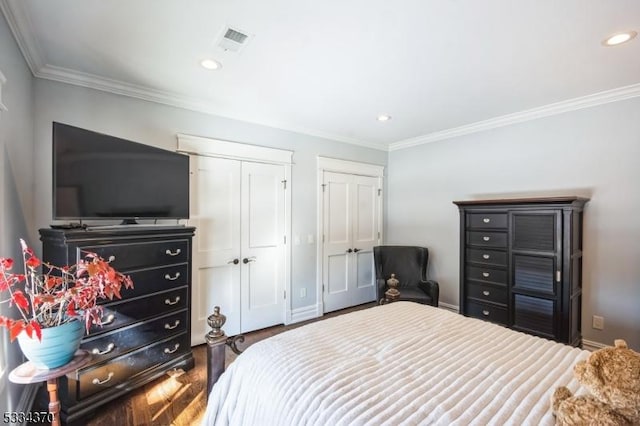 bedroom with crown molding and multiple closets