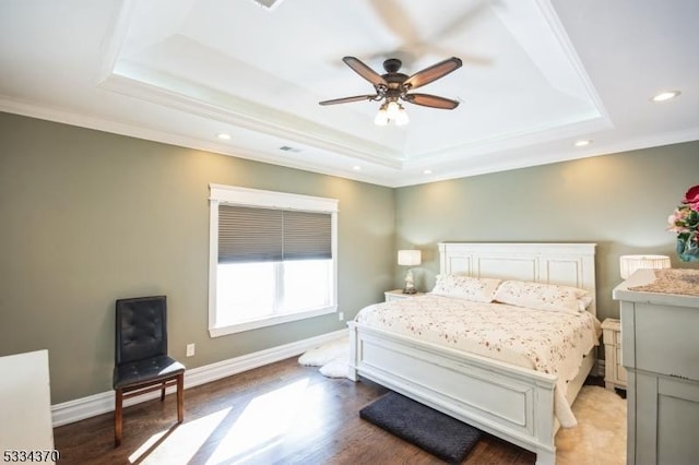 bedroom with wood-type flooring, ornamental molding, a raised ceiling, and ceiling fan